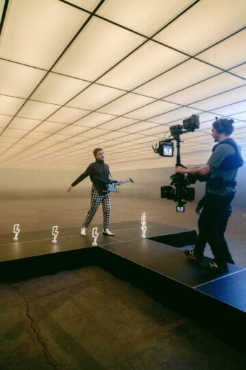 Man with guitar on a soundstage